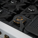 Close-up of a brass burner on the Forno Antico 48-Inch Gas Range in white, highlighting the precision flame ports, durable cast iron grate, and elegant matte white cooktop surface.